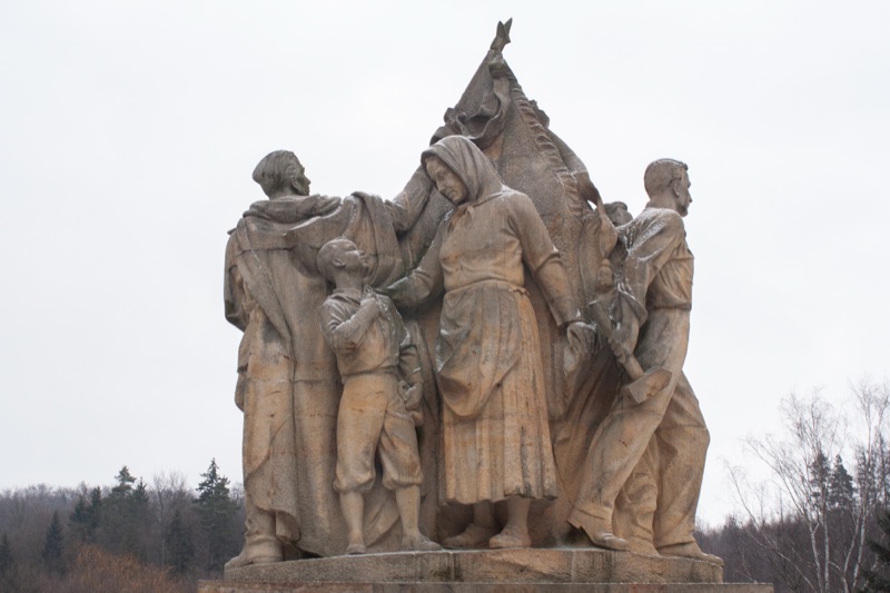 A socialist-realist commemorative monument depicting a group of figures with a banner